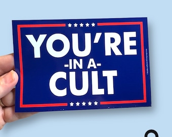 May include: A blue and red rectangular sign with white text that reads "You're -in a- CULT".