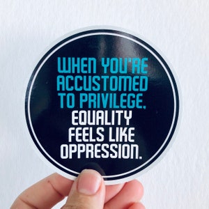 May include: A black and white round sticker with the text "When you're accustomed to privilege, equality feels like oppression." in blue.