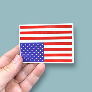 May include: A sticker of the American flag, but the stars are upside down. The flag is red, white, and blue.