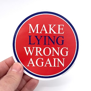 May include: A red and blue circular sticker with the text "MAKE LYING WRONG AGAIN" in white letters.