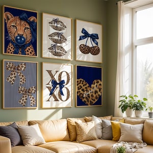 May include: A set of six framed wall art prints featuring a leopard print theme with navy blue bows. The designs include a cheetah blowing a bubble, leopard print lips, cherries, bows on striped backgrounds, XOXO text, and a heart with Lucky girl text.