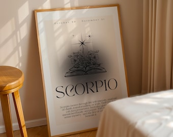 May include: A framed poster with a beige background features the word "SCORPIO" in large, elegant font. The artwork includes a starburst design, flowers, and an open book illustration. Text at the bottom describes Scorpio traits. The frame is a light brown color.