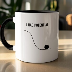 May include: A white ceramic mug with a black handle and interior. The exterior features the black text I HAD POTENTIAL above a black line graphic showing a downward curve ending in a flat line with a small black circle resting at the bottom.