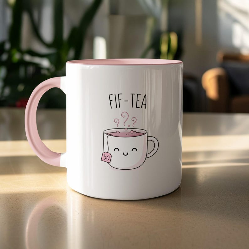 White mug with pink handle, "Fifi-Tea" text and a smiling teabag graphic.