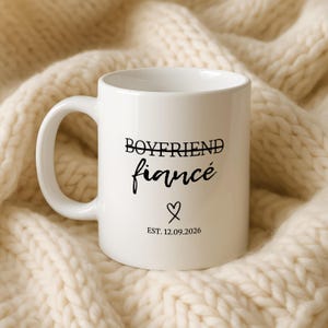 White mug with "Boyfriend Fiancé Est. 12.09.2026" text and heart.