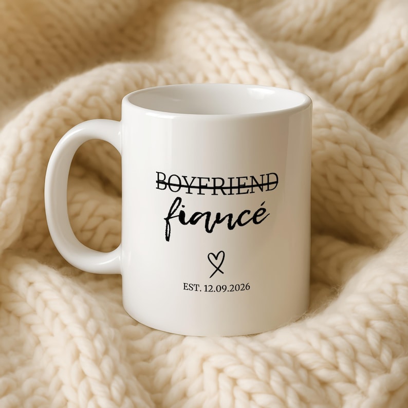 White mug with "Boyfriend Fiancé Est. 12.09.2026" text and heart.
