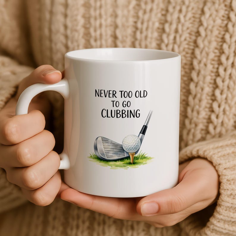 White mug with text "Never too old to go clubbing" and golf club with ball.