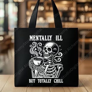 Puede incluir: Bolso tote negro con un gráfico blanco de un esqueleto sosteniendo una taza de café, con el texto "MENTALLY ILL BUT TOTALLY CHILL". El bolso tiene asas negras y está hecho de un material duradero.