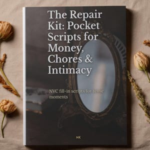 May include: A book titled "The Repair Kit: Pocket Scripts for Money, Chores & Intimacy" with a vintage mirror illustration on the cover. The book's cover is dark with white text. Dried flowers are placed around the book.
