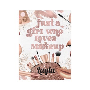 Op de afbeelding: Een witte achtergrond met roségouden make-upelementen en de tekst "Just a girl who loves Makeup". Een make-uptasje met de naam "Layla" is afgebeeld, samen met lippenstift, kwasten en oogschaduw.
