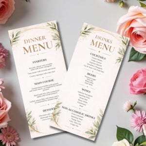 Könnte beinhalten: Zwei elegante Menükarten mit goldenem Text und floralen Akzenten. Auf einer steht "Dinner Menu" mit Vorspeisen, Hauptgerichten und Desserts. Die andere zeigt "Drinks Menu" mit Cocktails, Bieren, Weinen und alkoholfreien Getränken.