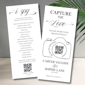 Può includere: Due cartelli nuziali bianchi con testo nero. Uno dice "i spy" ed elenca i momenti da fotografare. L'altro dice "Capture the Love" con una grafica della fotocamera e un codice QR per la condivisione di foto. Tema del matrimonio.