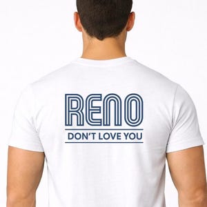 May include: A white ceramic mug with a black handle and the text "But First, Coffee" in a bold, black font. The mug is set against a blurred background, suggesting a cozy setting.