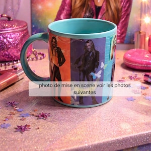 May include: A teal ceramic mug with a matching handle. The mug features images of people on a colorful background. The text "photo de mise en scene voir les photos suivantes" is printed on the mug.