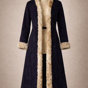 Puede incluir: Abrigo largo azul marino con ribete de piel sintética alrededor del cuello, la parte delantera y los puños. El abrigo se exhibe en un maniquí y tiene un cinturón en la cintura.