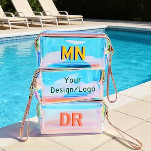 May include: Three iridescent cosmetic bags stacked on top of each other, with a pool in the background. Each bag has a zipper closure and a wrist strap. The top bag has the letters "MN", the middle bag has "Your Design/Logo", and the bottom bag has "DR".