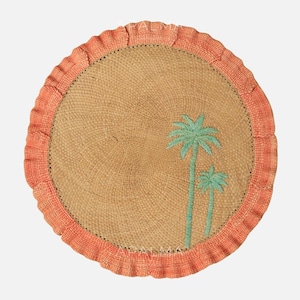 May include: A round woven placemat with a natural tan center and a ruffled coral-colored border. The center features an embroidered design of two light green palm trees. The word APALMA is printed in small white letters at the top and bottom.