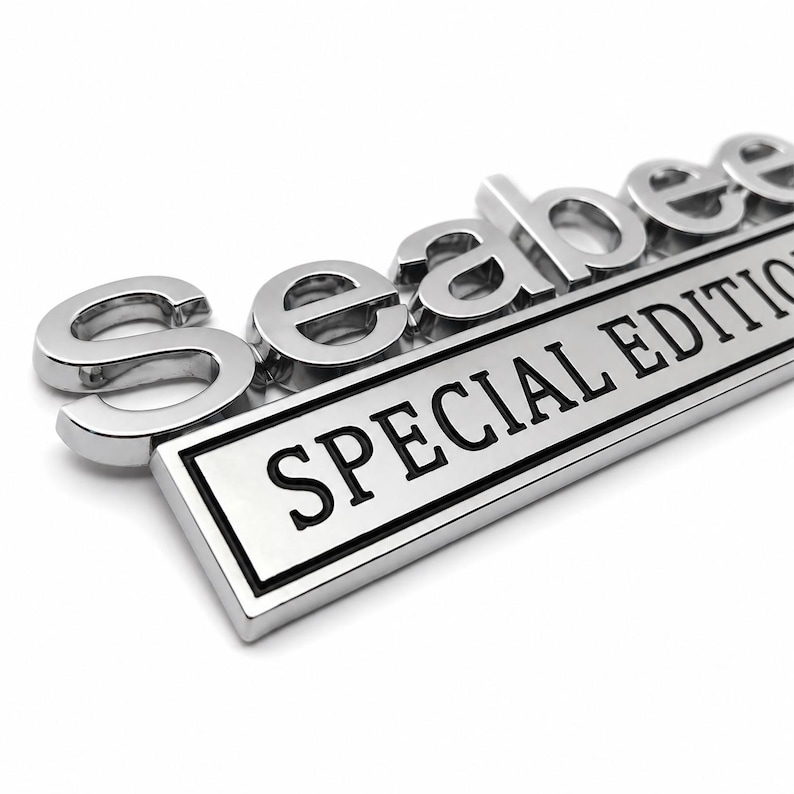 Pu&ograve; includere: Un'emblema cromato con la parola "Seabee" in lettere in rilievo sopra una placca rettangolare. La placca riporta le parole "SPECIAL EDITION" in lettere nere.