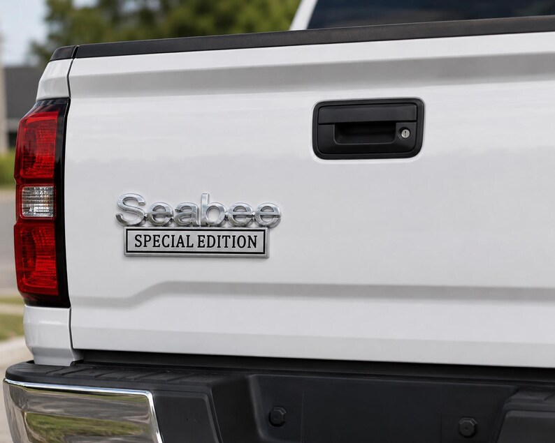 Pu&ograve; includere: Primo piano del retro di un camion bianco con maniglia nera e fanale posteriore rosso. L'emblema cromato recita "Seabee SPECIAL EDITION". Il cassone &egrave; pulito, con un paraurti nero.