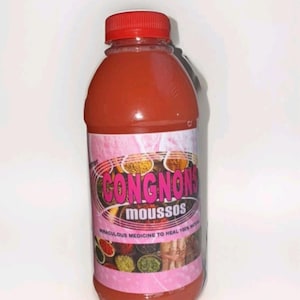 May include: A clear plastic bottle filled with a reddish liquid, topped with a red cap. The bottle has a pink label with the text "CONGNONS moussos" and other text, along with illustrations of spices. The label also states "miraculous medicine to heal 100% nature".