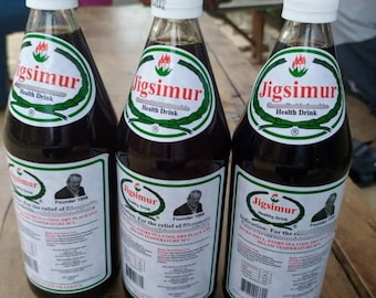 May include: Three glass bottles of "Jigsimur Health Drink" with white caps and labels. The labels feature a green and white design with the product name and a picture of a man. The bottles are filled with a dark liquid.
