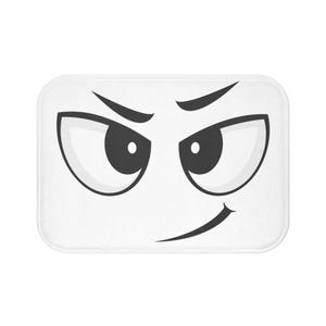 May include: White rectangular bath mat featuring a cartoon face with black eyes, eyebrows, and a curved mouth. The design has a simple, bold style, perfect for a bathroom or kids' room.