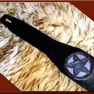 May include: Black leather guitar strap with a silver pentagram design in a red circle.