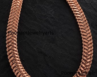 May include: A rose gold-toned chain necklace featuring a dense, interlocking herringbone-style link pattern. The necklace is secured with a hook-style clasp at the top. The text PoonamJewelryarts is visible across the center and bottom right.