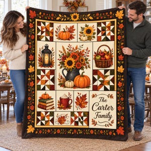 May include: A rectangular throw blanket featuring a patchwork-style autumn design with sunflowers, pumpkins, a lantern, a basket of apples, and a stack of books. The center displays a floral arrangement, and the text reads The Carter Family.