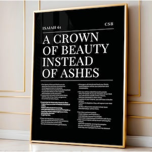 May include: A framed black and white art print with gold trim. The print features the text "A CROWN OF BEAUTY INSTEAD OF ASHES" from Isaiah 61. The text is in a bold, sans-serif font. The print also includes Bible verses.