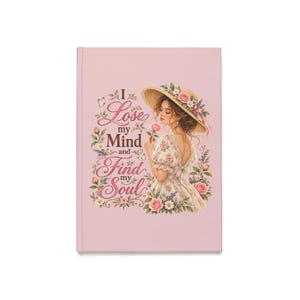 Könnte beinhalten: Ein hellrosa Notizbuch mit festem Einband und einer Illustration einer Person in einem Blumenkleid und einem mit Blumen geschmückten Strohhut. Der Text lautet I Lose my Mind and Find my Soul, umgeben von rosa Rosen, kleinen weißen Blumen und Schmetterlingen.
