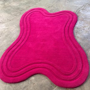 Puede incluir: Una taza de cerámica blanca con un asa negra y el texto "But First, Coffee" en negro, con una fuente de estilo manuscrito. La taza está sobre una superficie blanca.