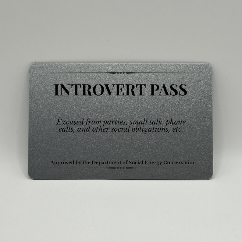 May include: A gray card with rounded corners, featuring the text "INTROVERT PASS" in bold black letters. Below, smaller text reads "Excused from parties, small talk, phone calls, and other social obligations, etc."