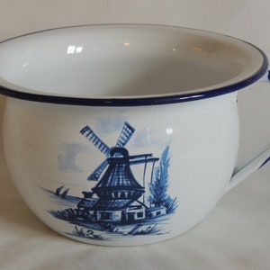 May include: White enamel chamber pot with a blue windmill scene. The pot has a rounded shape, a handle, and a blue rim. A classic piece of Delftware pottery.