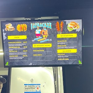 May include: A digital menu board displaying food options, including burgers, tacos, and sides. The menu is divided into sections like 'Main', '$3 Starters', and '$4 Sides'. The sign also has the text "CLOSED" with a call to return.