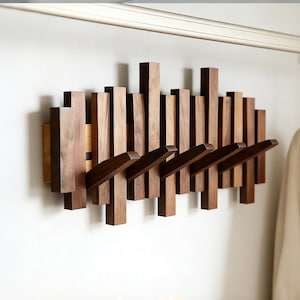 Puede incluir: Un juego de tres tazas de cerámica con un acabado mate moteado. Las tazas son en tonos crema, gris claro y gris oscuro. Cada taza tiene un diseño simple y minimalista y un asa redondeada.