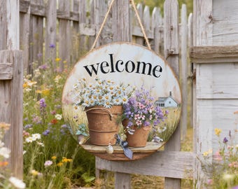 May include: Round wooden welcome sign with a painted floral design. The sign features the word "welcome" in black script. Two metal buckets filled with daisies and lavender are depicted. The sign hangs from a wooden fence with a rope.