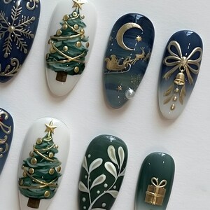 May include: A collection of Christmas-themed nail art designs. The nails feature festive elements like Christmas trees, snowflakes, a crescent moon with Santa's sleigh, and gift boxes, all in gold and green hues. The designs are set against a white background.