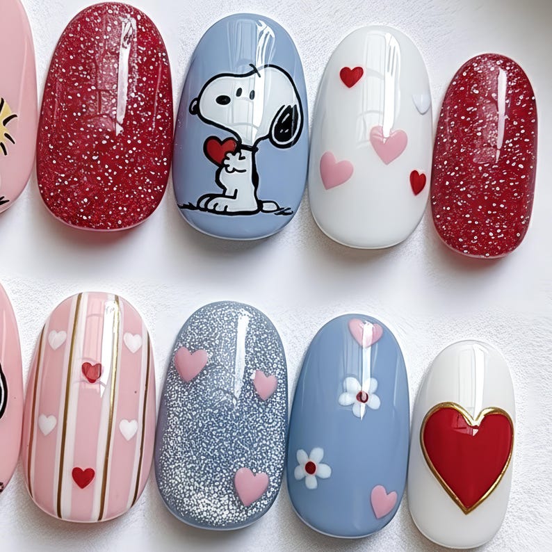 May include: A set of oval-shaped artificial nails with various designs. Some nails are red glitter, others feature Snoopy holding a heart, pink and red hearts, stripes, and floral patterns. The nails are painted in shades of pink, white, and blue.