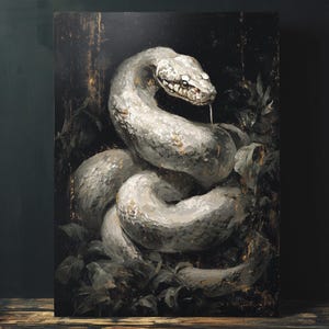 Puede incluir: Impresión en lienzo que representa una serpiente blanca enroscada, con una cabeza detallada y una lengua bífida. La serpiente se encuentra sobre un fondo oscuro y texturizado con toques de follaje. La obra tiene un estilo pictórico.