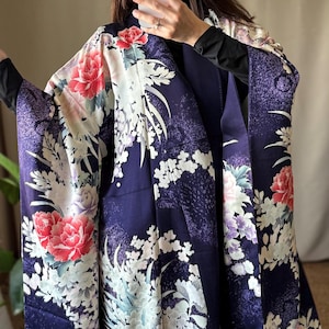 May include: A dark purple kimono featuring a vibrant floral pattern with large red and white peony blossoms, smaller light purple flowers, and white foliage accents. The fabric has a subtle speckled texture throughout the deep violet base color.