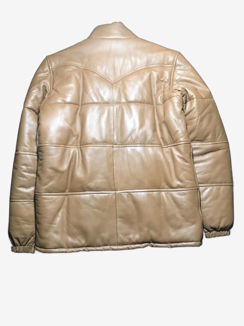 K&ouml;nnte beinhalten: Hellbraune Lederjacke mit Steppdesign. Die Jacke hat einen klassischen Kragen und eine Knopfleiste. Die &Auml;rmel haben elastische B&uuml;ndchen. Der R&uuml;cken der Jacke hat einen dekorativen Einsatz.