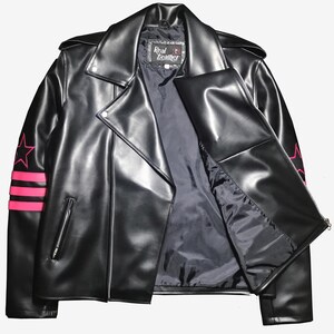 May include: Black leather jacket with a classic biker style, featuring a notched collar, asymmetrical zipper, and pink star and stripe accents on the sleeves. The jacket has a "Real Leather" label.