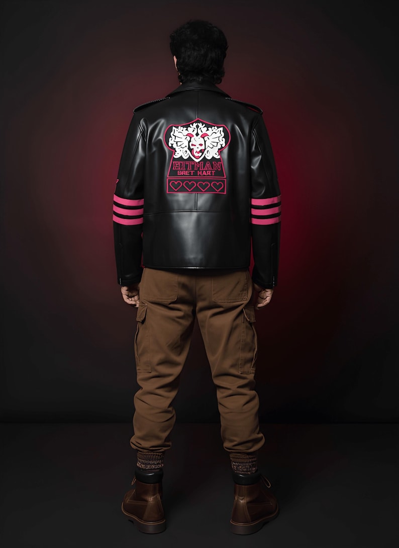 May include: Black leather jacket with pink accents and the text "HITMAN BRET HART" on the back. The jacket has pink stripes on the sleeves and is paired with brown cargo pants and boots. The overall style is edgy and bold.