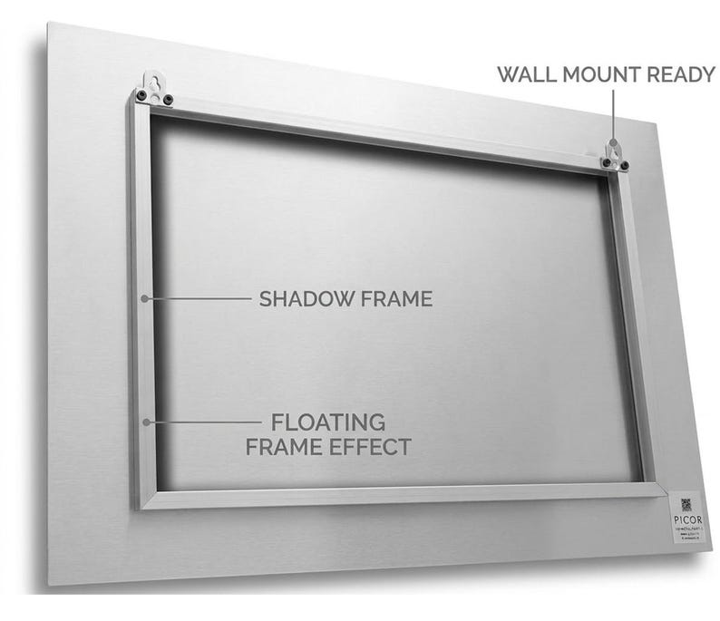 Puede incluir: Un marco de metal plateado con un marco de sombra y un efecto de marco flotante. Las palabras "WALL MOUNT READY" son visibles, junto con el texto "SHADOW FRAME" y "FLOATING FRAME EFFECT". El marco tiene herrajes para montaje en pared.