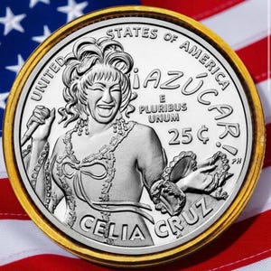 Può includere: Una moneta color argento con bordo dorato raffigurante Celia Cruz, con la scritta "AZÚCAR!" e "25¢". La moneta è posta su uno sfondo della bandiera americana.