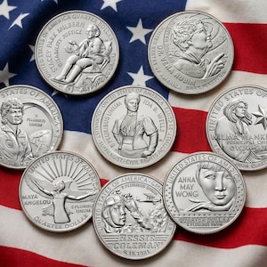 Pode incluir: Oito moedas de vinte e cinco centavos dos Estados Unidos de cor prateada com retratos e inscrições de figuras notáveis, incluindo Stacey Park Milburn, Dr. Vera Rubin, Ida B. Wells, Wilma Mankiller, Maya Angelou, Bessie Coleman e Anna May Wong.