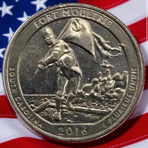 May include: A United States quarter coin from 2016 featuring a detailed engraving of a soldier holding a flag, with the words "Fort Moultrie" and "South Carolina" inscribed. The coin is set against a backdrop of the American flag.