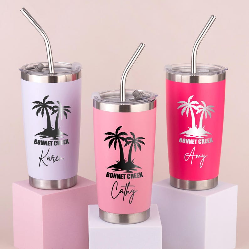 May include: Three stainless steel tumblers in lavender, pink, and hot pink, each with a silver lid and straw. The tumblers feature a black palm tree design with the text "Bonnet Creek" and a name in a script font.