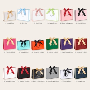 May include: A collection of eighteen rectangular gift bags arranged in three rows, each featuring a satin ribbon bow, cord handles, and contrasting edge trim. The bags are displayed in various colour combinations including ivory, pink, green, and navy.